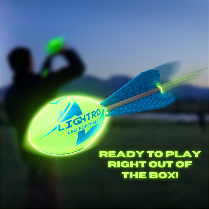 A LIGHTRO LED Football from Cassidy Labs, featuring a vivid green glow and dazzling tail, soars through the dusk as someone gets ready to catch it. Bold text: READY TO PLAY RIGHT OUT OF THE BOX!.